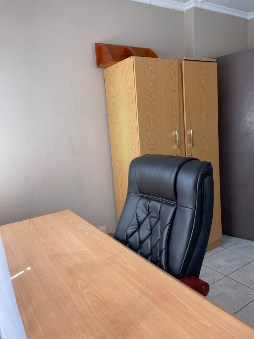 Work desk with a black leather chair and a wooden wardrobe