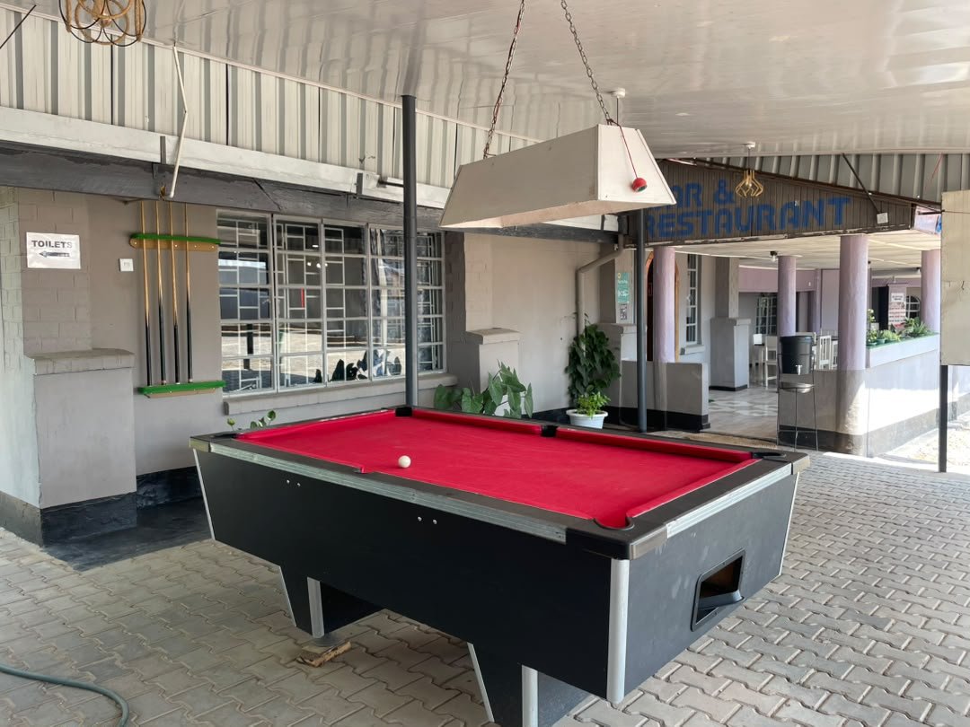 Pool table and cue rack in the covered area beside the bar and restaurant